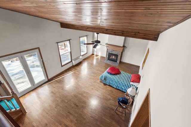 unfurnished living room with hardwood / wood-style floors, a brick fireplace, lofted ceiling, and wood ceiling