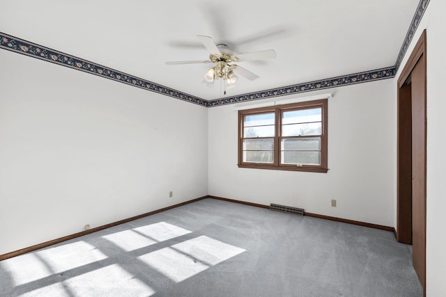 carpeted spare room featuring ceiling fan