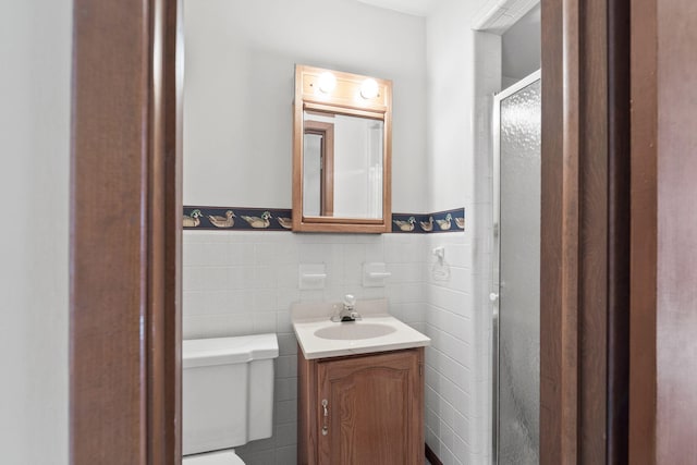 bathroom featuring vanity, an enclosed shower, tile walls, and toilet