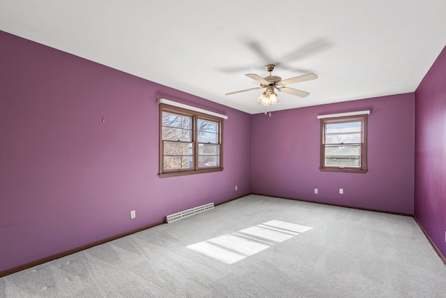 empty room featuring light colored carpet, a wealth of natural light, and ceiling fan