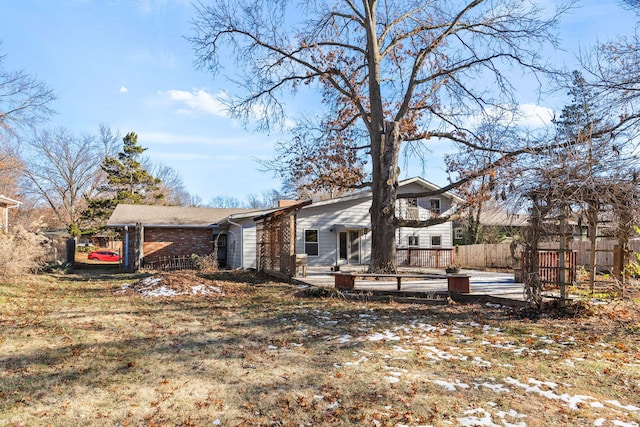 rear view of property with a lawn and a deck