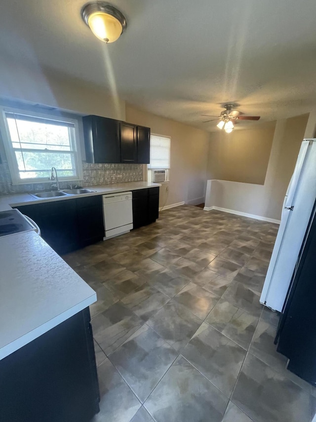 kitchen featuring tasteful backsplash, ceiling fan, sink, dishwasher, and range