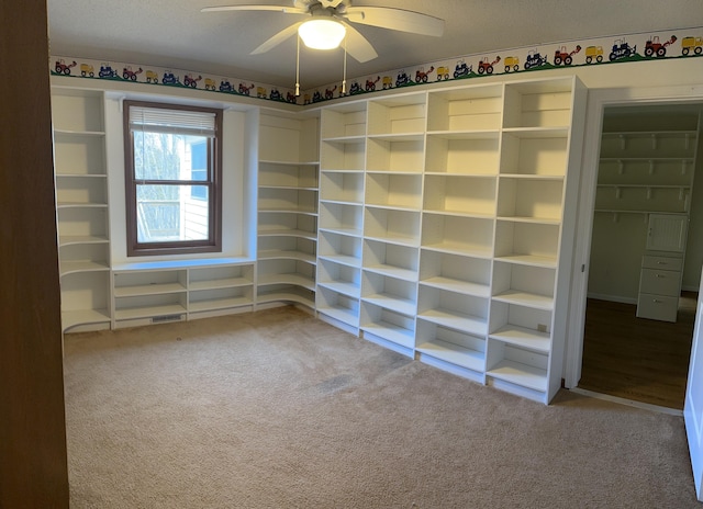 carpeted spare room with a textured ceiling and ceiling fan