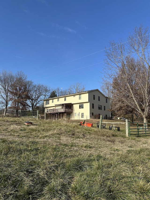 back of property with a rural view and a wooden deck