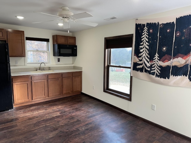 kitchen with a healthy amount of sunlight, dark hardwood / wood-style flooring, and black appliances