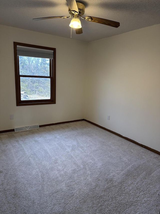 spare room with carpet flooring, a textured ceiling, and ceiling fan