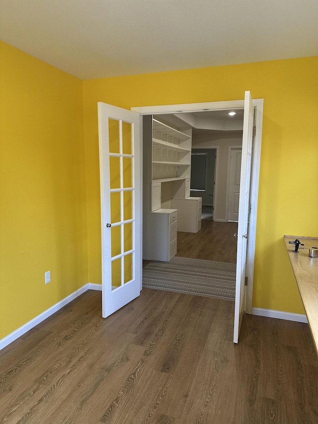 empty room featuring french doors and dark hardwood / wood-style floors