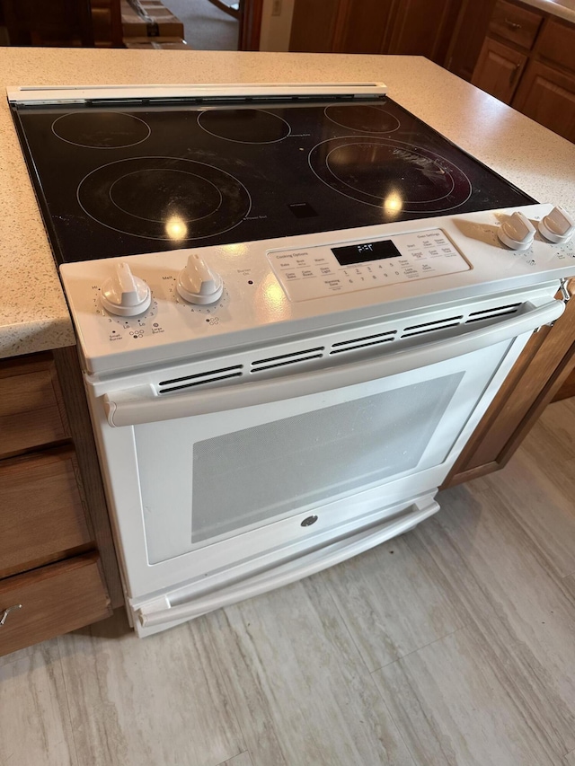 interior details featuring electric stove and light hardwood / wood-style flooring