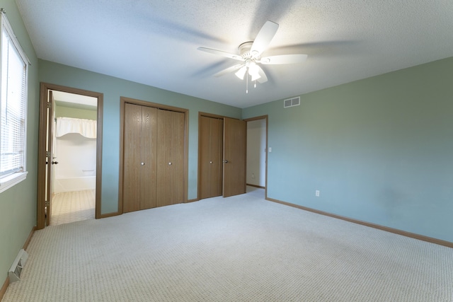 12500 W Rocheport Gravel Rd, Rocheport, MO 65279 - unfurnished bedroom featuring carpet, visible vents, two closets, and a textured ceiling