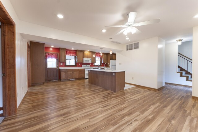 12500 W Rocheport Gravel Rd, Rocheport, MO 65279 - kitchen with visible vents, wood finished floors, white appliances, light countertops, and baseboards