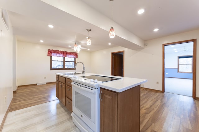 12500 W Rocheport Gravel Rd, Rocheport, MO 65279 - kitchen with light wood-style flooring, white range with electric cooktop, a sink, recessed lighting, and light countertops