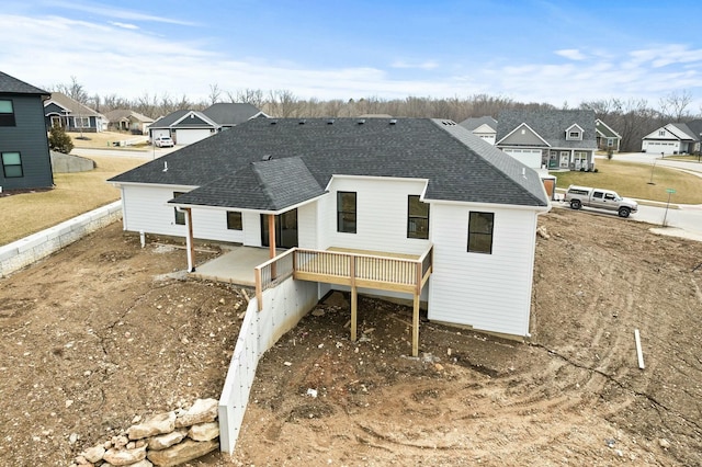 back of house with a shingled roof, a residential view, and a wooden deck