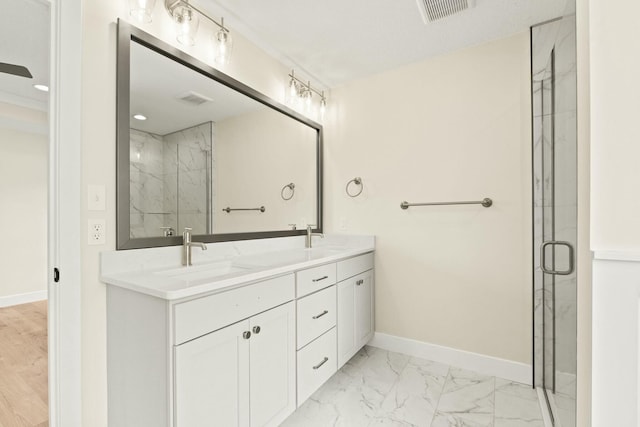 bathroom with marble finish floor, a sink, visible vents, and baseboards