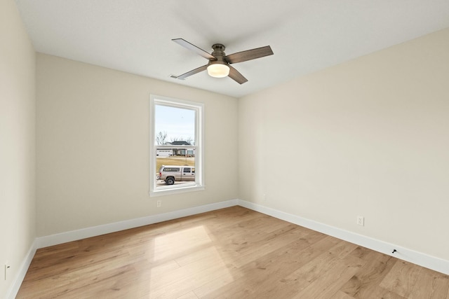 empty room featuring light wood-style floors, baseboards, and a ceiling fan