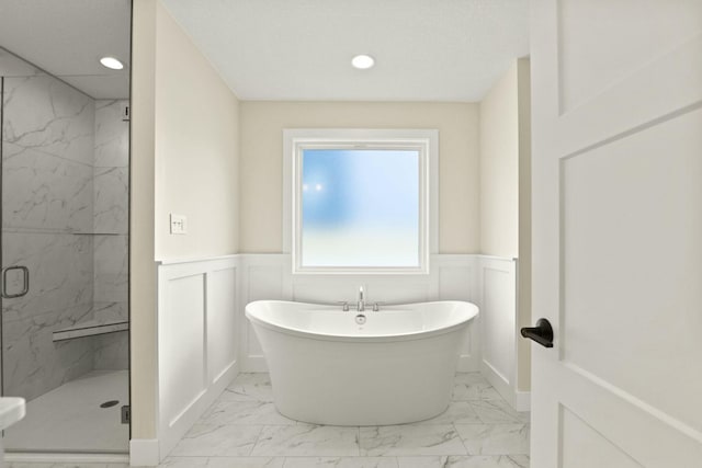 bathroom featuring a marble finish shower, wainscoting, marble finish floor, a freestanding bath, and recessed lighting