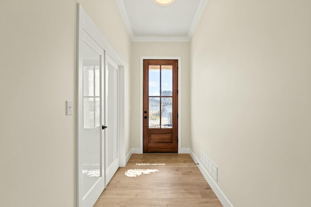 doorway to outside featuring light wood finished floors, baseboards, visible vents, and ornamental molding