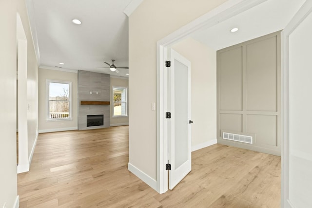 hall featuring recessed lighting, visible vents, baseboards, ornamental molding, and light wood-type flooring