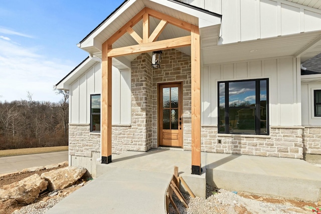 entrance to property featuring stone siding and board and batten siding