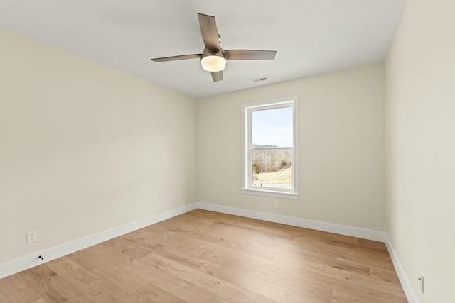 unfurnished room featuring ceiling fan, visible vents, light wood-style flooring, and baseboards