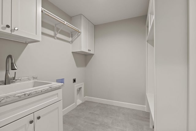 laundry room with baseboards, a sink, cabinet space, and hookup for an electric dryer