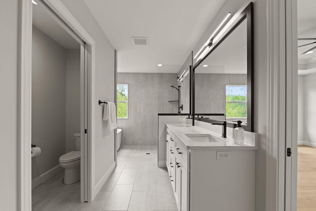 full bathroom featuring visible vents, double vanity, toilet, a sink, and a wealth of natural light