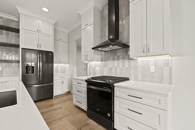 kitchen with stainless steel fridge with ice dispenser, black gas stove, light countertops, wall chimney exhaust hood, and tasteful backsplash