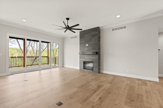 unfurnished living room featuring ornamental molding, a ceiling fan, and visible vents
