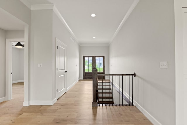 hall with crown molding, baseboards, recessed lighting, light wood finished floors, and an upstairs landing