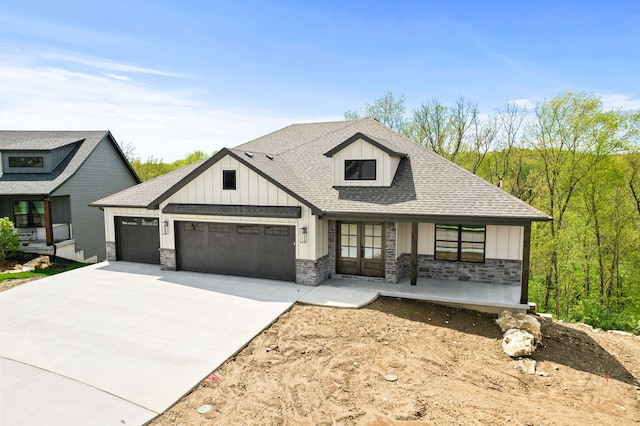 view of front of home featuring board and batten siding, a porch, driveway, roof with shingles, and an attached garage