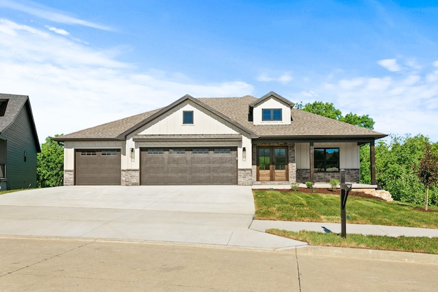 924 Engle Dr, Columbia, MO 65203 - view of front of property with an attached garage, board and batten siding, driveway, and stone siding