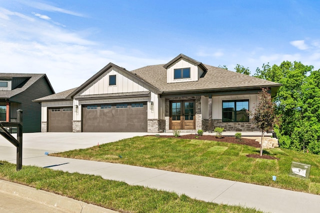 924 Engle Dr, Columbia, MO 65203 - view of front facade featuring board and batten siding, an attached garage, a front yard, stone siding, and driveway