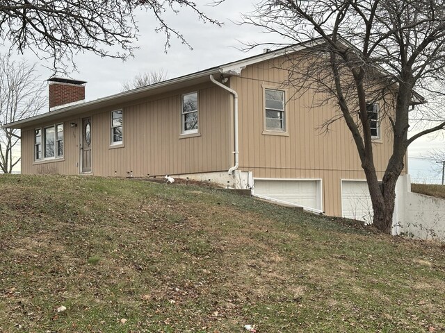 view of home's exterior featuring a lawn and a garage