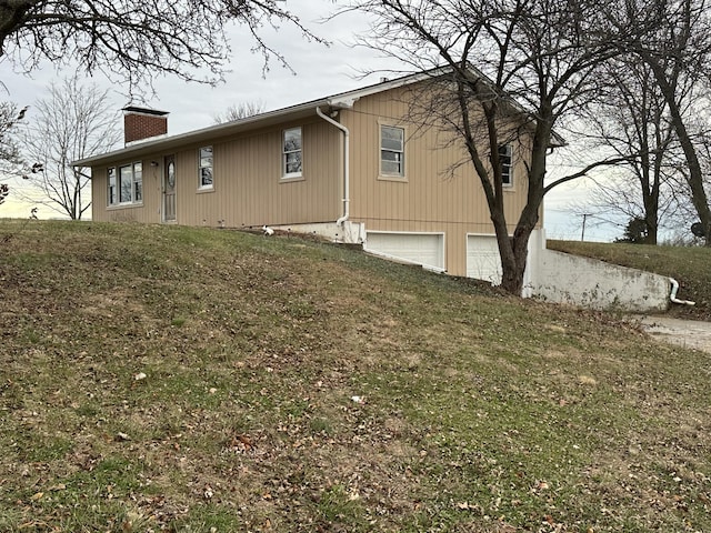 view of side of home with a lawn and a garage