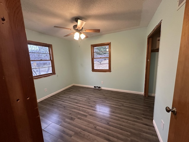 unfurnished bedroom featuring a textured ceiling, dark hardwood / wood-style floors, and ceiling fan