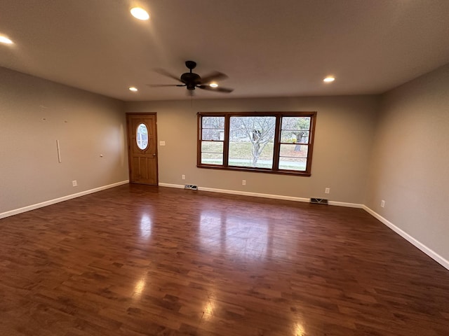 foyer entrance with ceiling fan and dark wood-type flooring