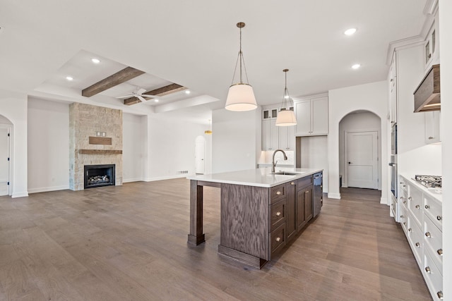 kitchen with white cabinets, dark brown cabinets, a kitchen island with sink, and dark wood-type flooring