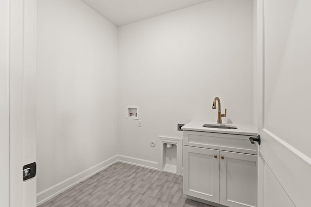 clothes washing area with cabinets, hookup for a gas dryer, sink, hookup for a washing machine, and light wood-type flooring