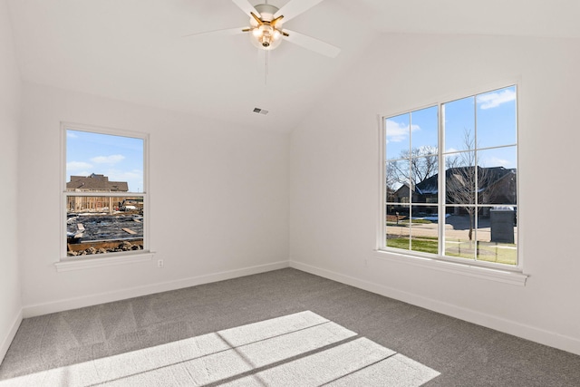 carpeted empty room with vaulted ceiling, ceiling fan, and a healthy amount of sunlight