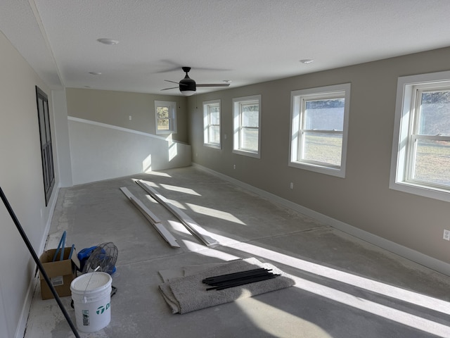 unfurnished room featuring a textured ceiling, a wealth of natural light, and ceiling fan