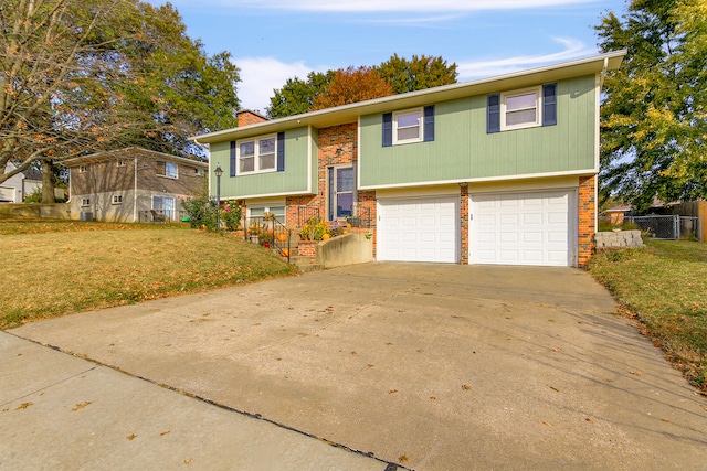 split foyer home featuring a garage and a front yard