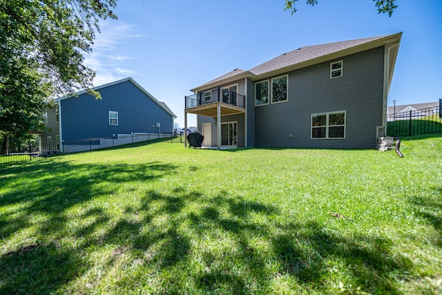 rear view of house with a lawn and a balcony