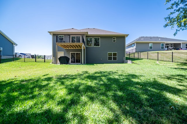 rear view of property featuring a balcony and a lawn