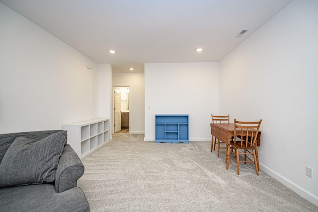 living area featuring light carpet