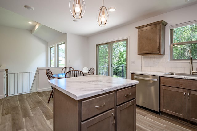 kitchen featuring a wealth of natural light, dishwasher, hanging light fixtures, and sink