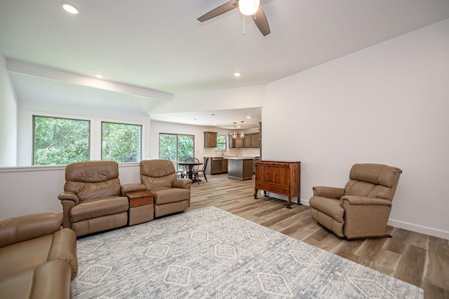 living room with light hardwood / wood-style floors and ceiling fan