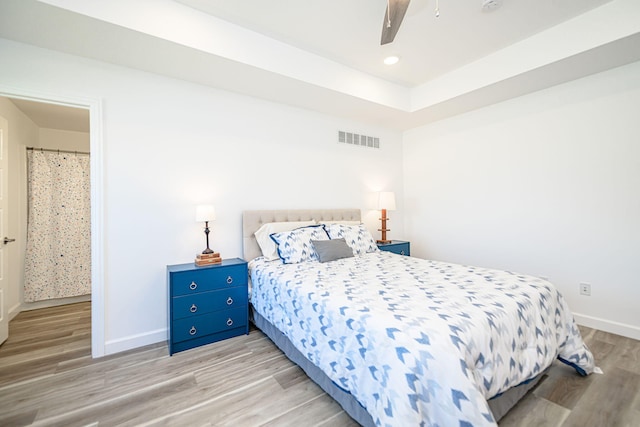 bedroom with ceiling fan, ensuite bathroom, and light hardwood / wood-style floors