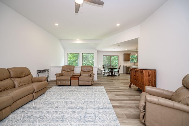 living room featuring ceiling fan and light hardwood / wood-style flooring