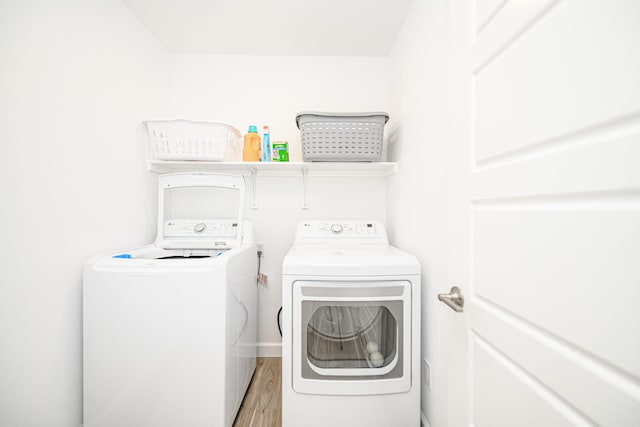 laundry area with hardwood / wood-style floors and washer and clothes dryer