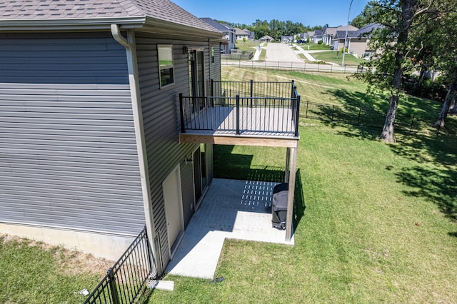 view of side of home featuring a lawn, a patio, and a deck