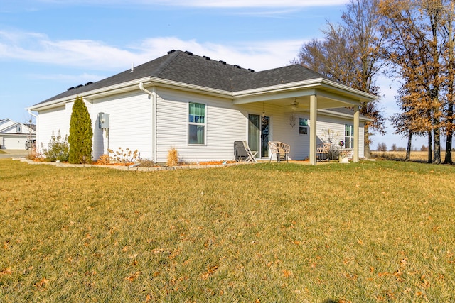 rear view of house featuring ceiling fan and a lawn